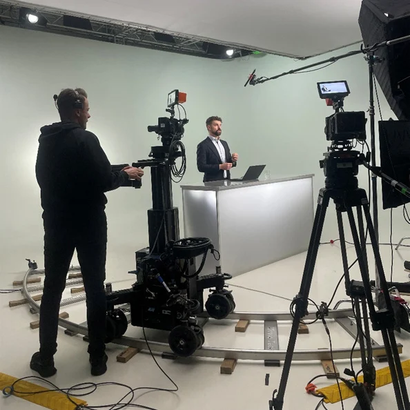 Behind-the-Scenes-Aufnahme aus dem Produktionsstudio des ZEDAL eLearning mit Kameramann, Kamerakran und Sprecher am Pult